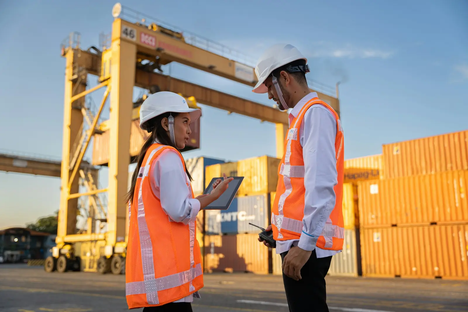 Two logistics professionals reviewing plans at a container terminal