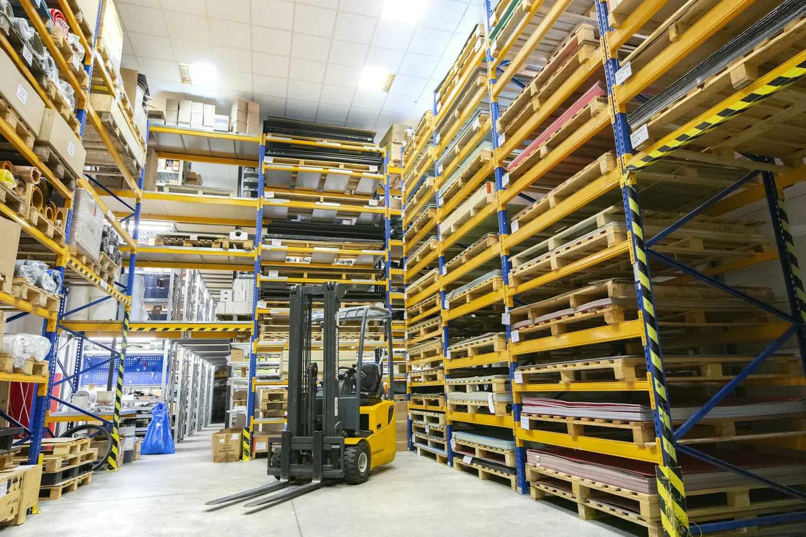 A forklift inside a warehouse with pallet racking
